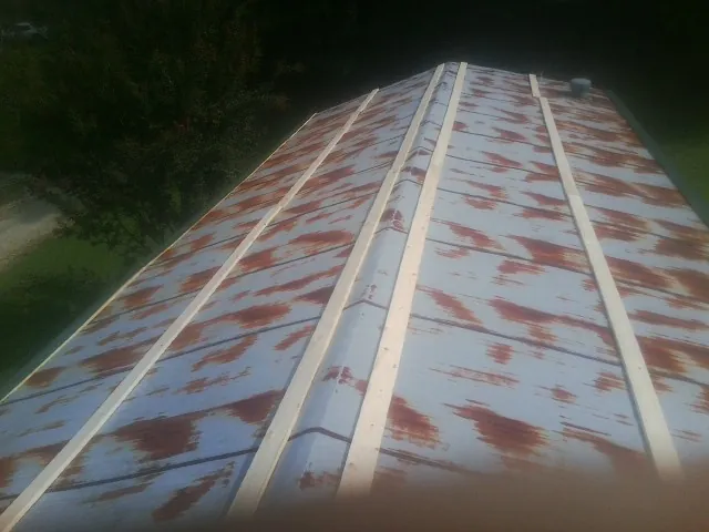 Rusted metal roof panels with new wood purlins before replacement — Storm Damage Roof Repair in Munnsville by Roofing Brothers
