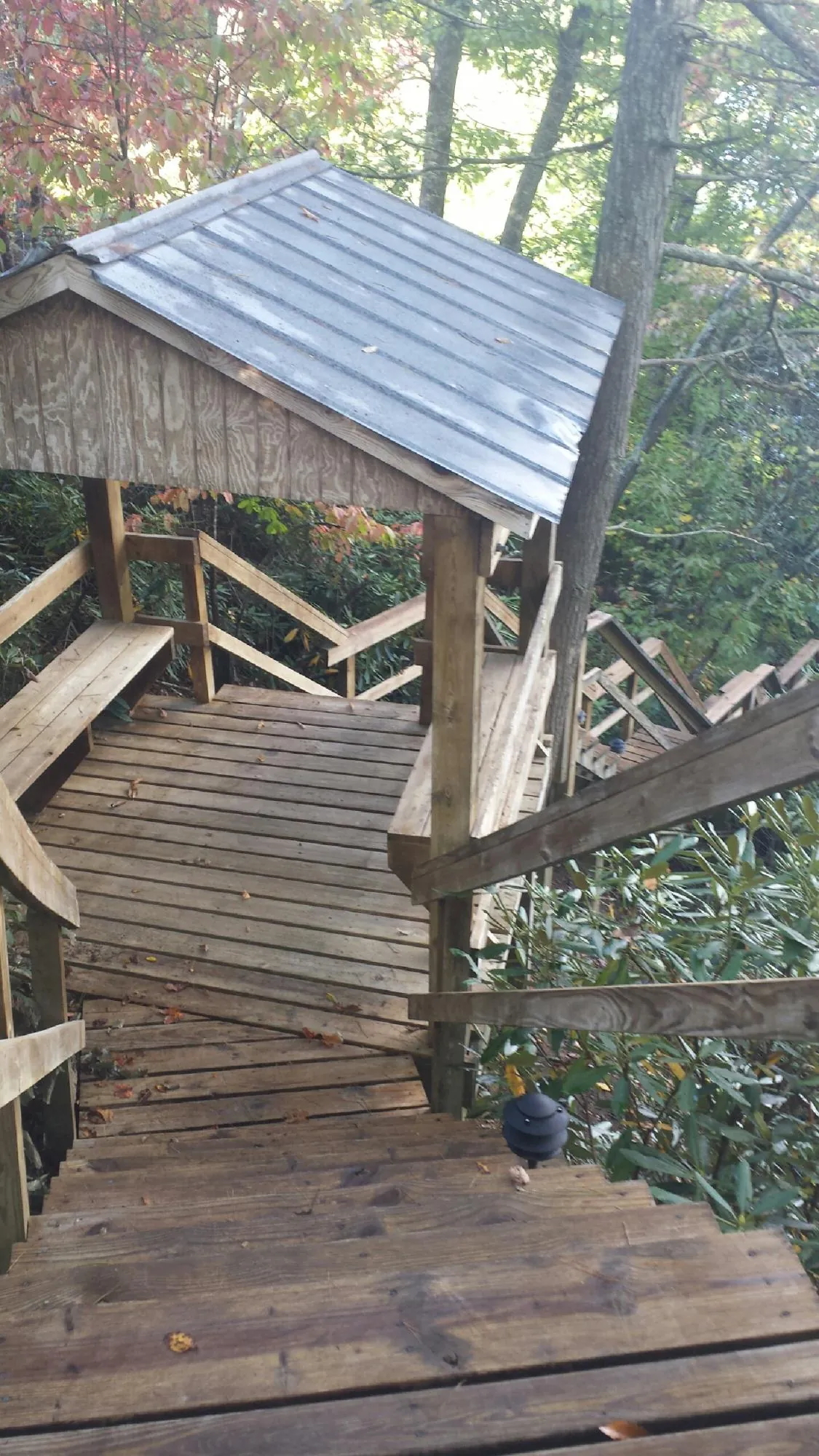 Metal roofed shelter over wooden steps on a wooded walkway — Skylight Repair & Installation work by our crew in Munnsville