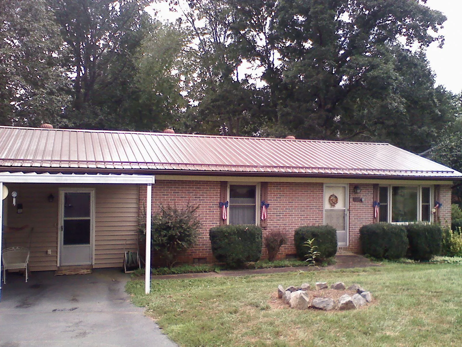 Bronze metal roof and carport on a brick ranch home — Roof Repair work by our crew in Munnsville