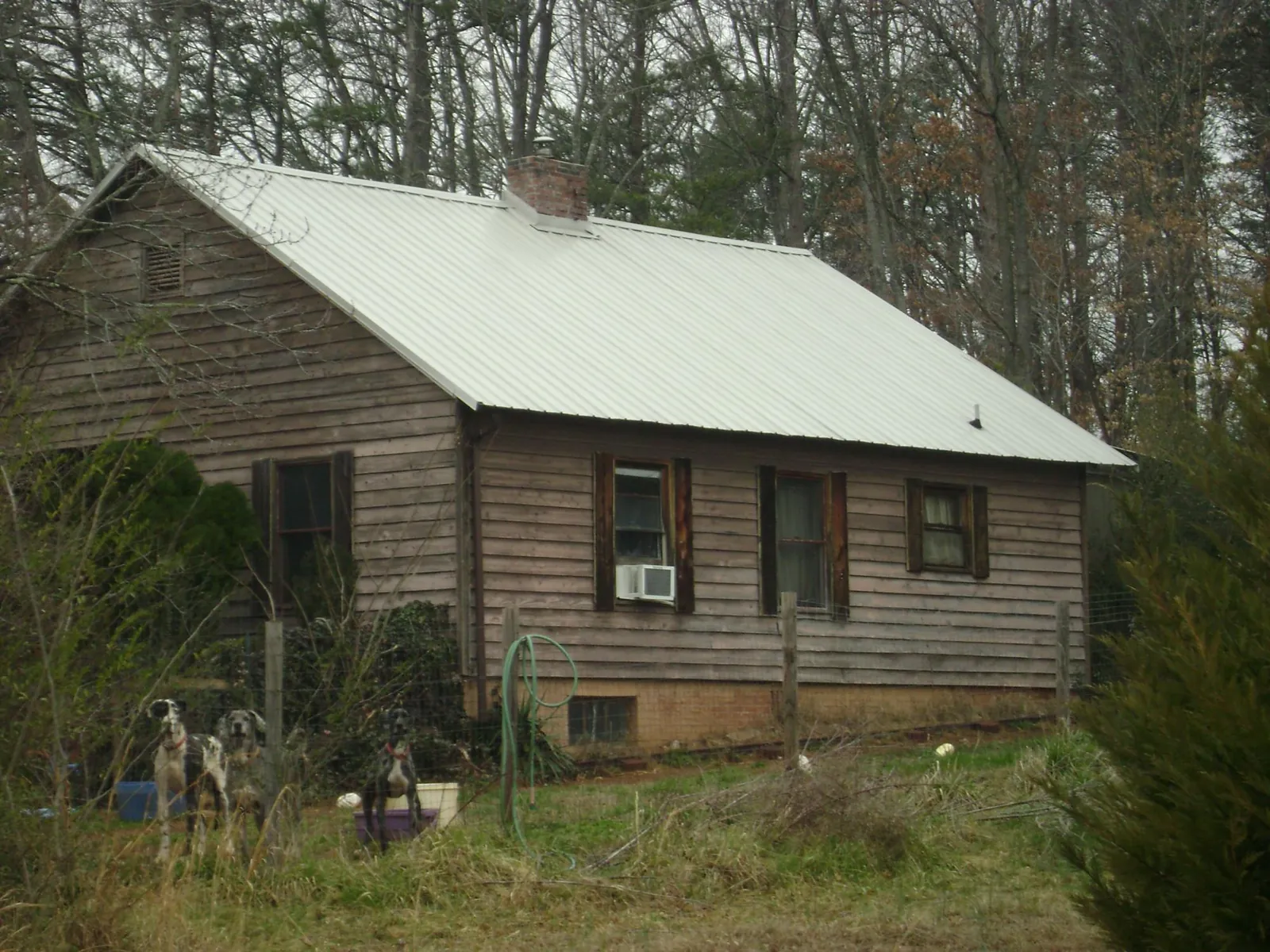 White metal roof on an old wood sided farmhouse, from a Metal Roof Installation job in Munnsville